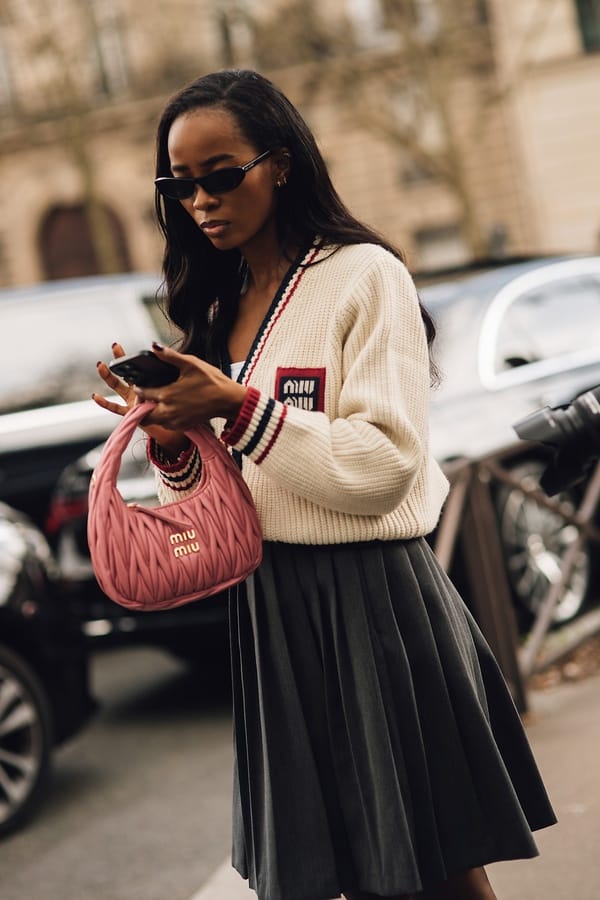 Grauer Faltenrock mit Strickjacke und rosa Tasche, Streetstyle Paris